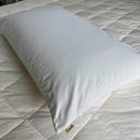 White pillow on a bed with 'Comfi' brand label